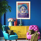 Baby boy in blue hat framed in room with pink and aqua chairs