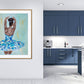 Print featuring black or african american ballerina in blue, aqua, white and gold tutu with soft green background with gold accents in hallway next to blue kitchen